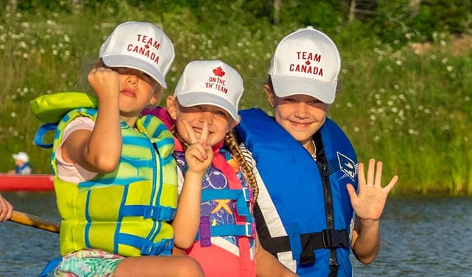 Drei fröhliche Mädchen in Kanada beim Kanu fahren